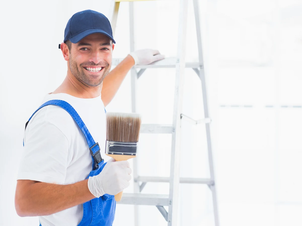Reading Decorators painter smiling and holding tools, plasterboard painting costs in Reading