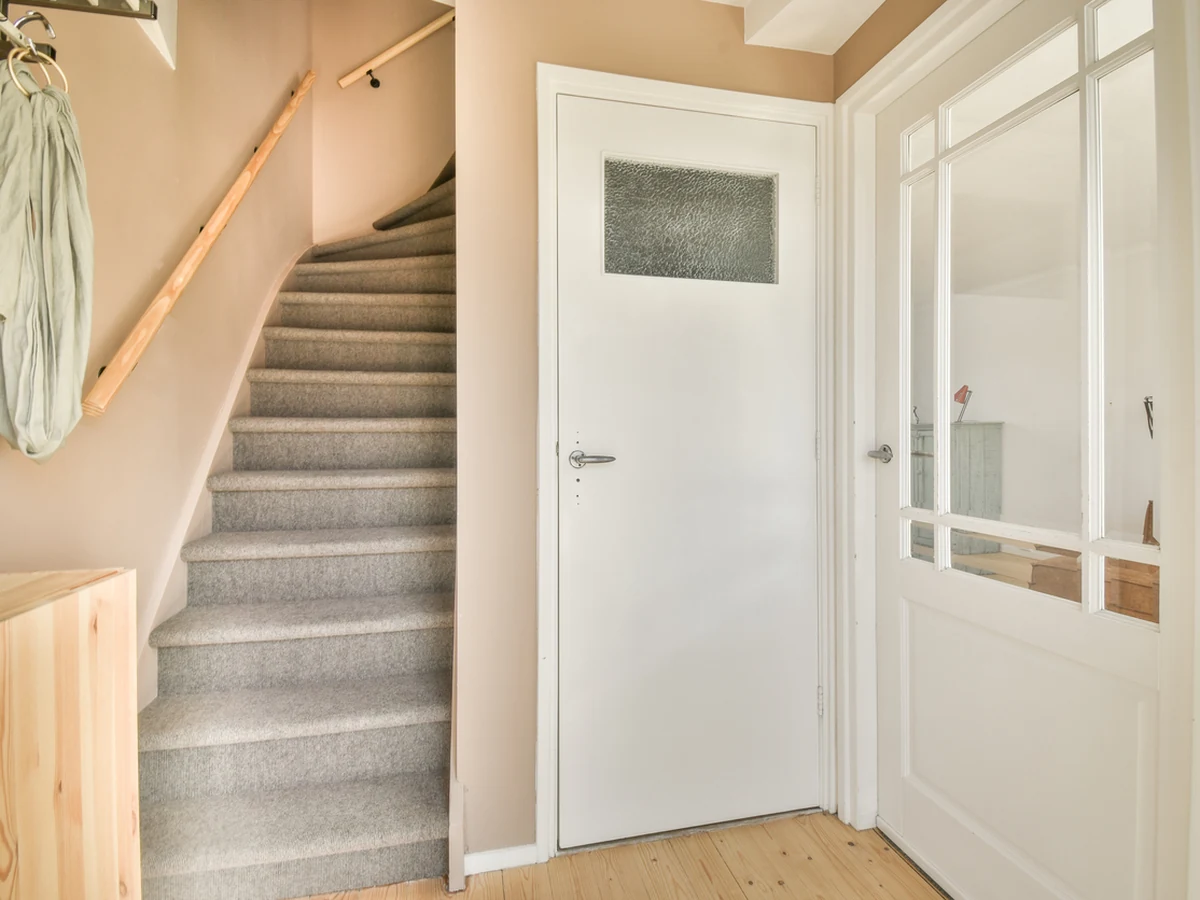 Bright hallway with carpeted staircase painted by Reading Decorators